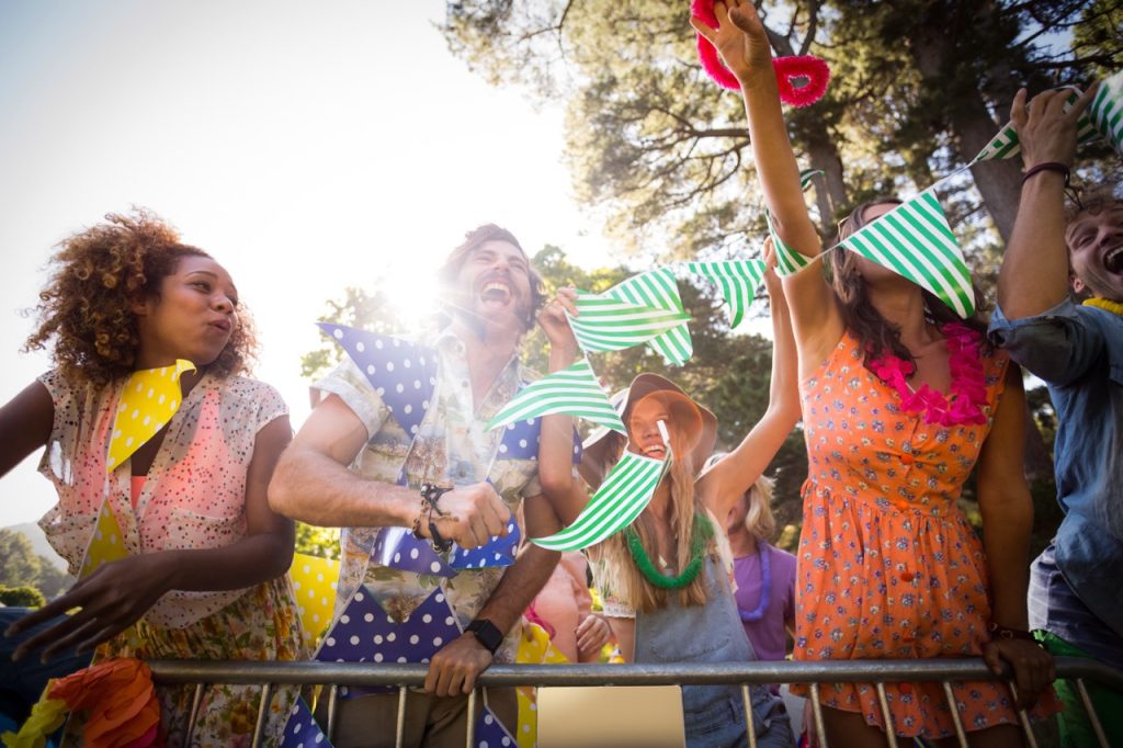 Friends dancing at music festival in park on a sunny day