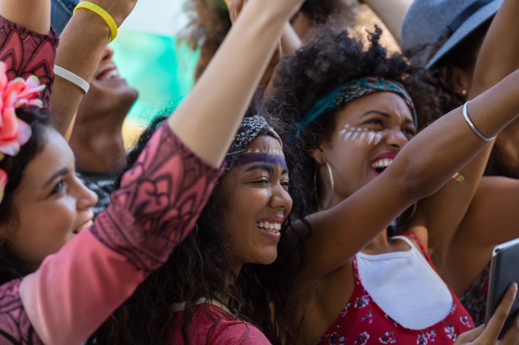 Beautiful woman taking selfie on mobile phone while dancing in the music festival